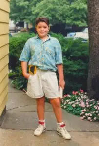 Dana Nielsen outdoors in Geneva, Illinois circa 1991, wearing headphones with a Sony Sports Walkman and holding a book.
