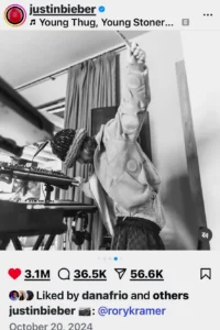Black and White photo of Justin Bieber playing synthesizer with one hand, other arm raised, holding drum stick